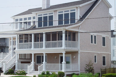 Imagen de fachada de casa beige costera de tres plantas con tejado a dos aguas