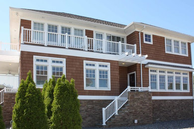 Modelo de fachada de casa marrón costera de tamaño medio de tres plantas con revestimientos combinados, tejado a cuatro aguas y tejado de teja de madera