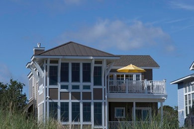 Diseño de fachada de casa beige tradicional renovada de tres plantas con revestimientos combinados y tejado de metal