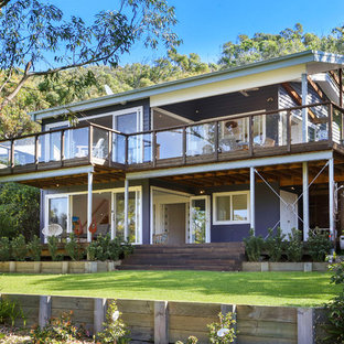 Inspiration for a beach style two-storey purple house exterior in Wollongong with a gable roof.