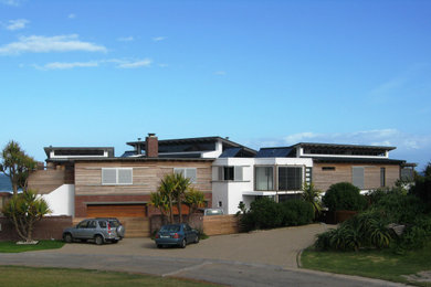 Foto de fachada de casa blanca actual grande de dos plantas con revestimientos combinados, tejado plano y tejado de metal