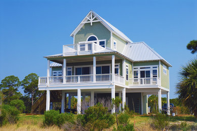 Ejemplo de fachada de casa verde costera grande de tres plantas con revestimientos combinados, tejado a dos aguas y tejado de metal