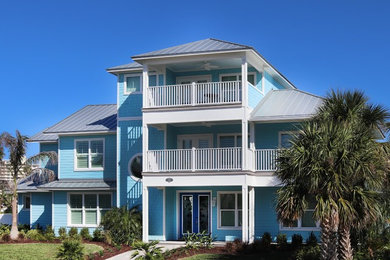 Large coastal blue three-story wood house exterior idea in Orlando with a hip roof and a metal roof