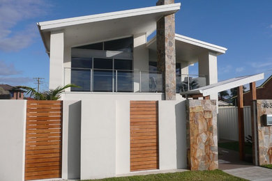 Diseño de fachada de casa blanca contemporánea grande de dos plantas con revestimiento de estuco, tejado de un solo tendido y tejado de metal