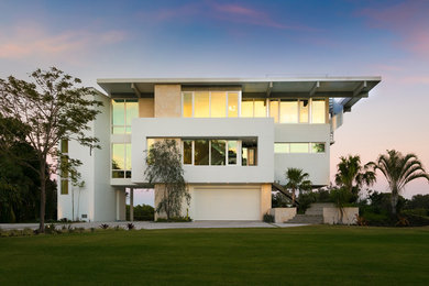 На фото: большой, трехэтажный, белый частный загородный дом в морском стиле с комбинированной облицовкой и плоской крышей с