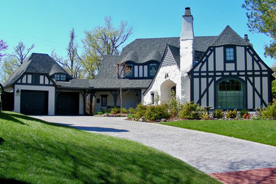 Mid-sized traditional white two-story stone house exterior idea in Other with a clipped gable roof and a shingle roof