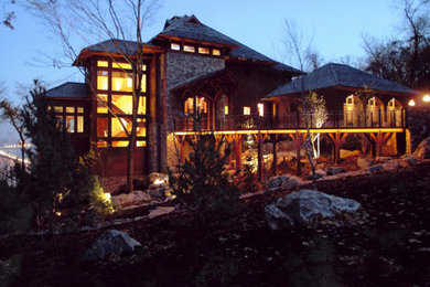 Foto della facciata di una casa grande marrone american style a due piani con rivestimenti misti e tetto a capanna