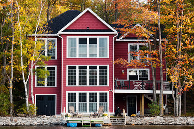 Diseño de fachada roja tradicional de tres plantas con revestimiento de madera