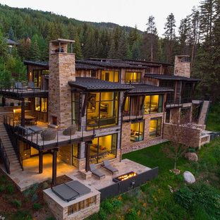 Example of a huge mountain style three-story mixed siding duplex exterior design in Denver with a shed roof and a metal roof