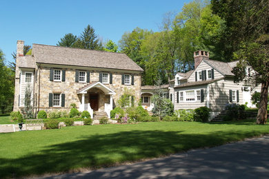 This is an example of a medium sized and beige classic two floor detached house in New York with stone cladding, a pitched roof and a shingle roof.