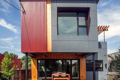 Ejemplo de fachada de casa roja contemporánea de tamaño medio de dos plantas con revestimientos combinados y tejado de un solo tendido