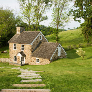 Idee per la facciata di una casa unifamiliare piccola beige country a due piani con rivestimento in pietra, tetto a capanna e copertura a scandole