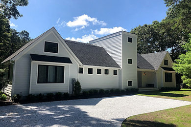 Example of a mid-sized transitional gray two-story concrete fiberboard exterior home design in New York with a shingle roof