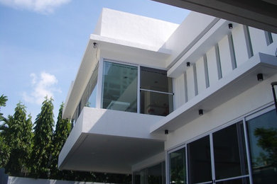 Example of a minimalist white two-story exterior home design in Other