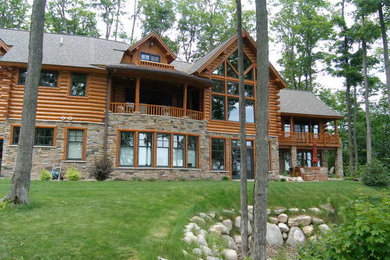 Example of a mid-sized mountain style brown two-story mixed siding gable roof design in Grand Rapids
