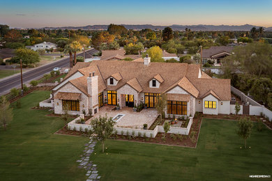 Large elegant beige one-story brick exterior home photo in Phoenix with a shingle roof