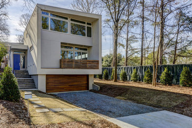 Diseño de fachada de casa blanca minimalista de tamaño medio de dos plantas con revestimiento de estuco y tejado plano