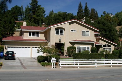 Example of a mid-sized classic beige two-story stucco gable roof design in Los Angeles