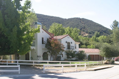 Example of a large tuscan white two-story stucco gable roof design in Los Angeles