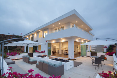 Example of a large trendy white two-story stucco exterior home design in San Diego