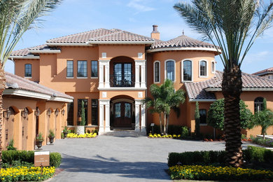 Large mediterranean brown two-story stucco gable roof idea in Orlando