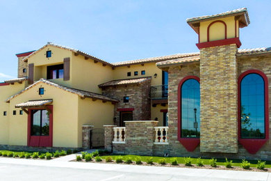フェニックスにある高級な地中海スタイルのおしゃれな家の外観 (混合材サイディング、黄色い外壁) の写真