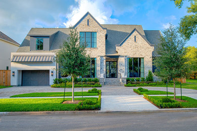 Inspiration for a large transitional gray two-story brick exterior home remodel in Houston with a shingle roof
