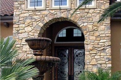 Large mediterranean brown two-story stone exterior home idea in Austin