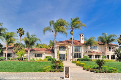 ロサンゼルスにあるラグジュアリーな巨大な地中海スタイルのおしゃれな家の外観 (漆喰サイディング) の写真