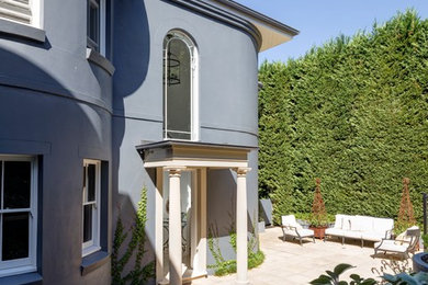Diseño de fachada gris tradicional renovada grande de dos plantas con revestimiento de estuco