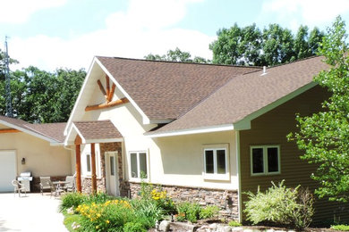 Diseño de fachada de casa beige clásica de tamaño medio de dos plantas con revestimientos combinados, tejado a dos aguas y tejado de teja de madera