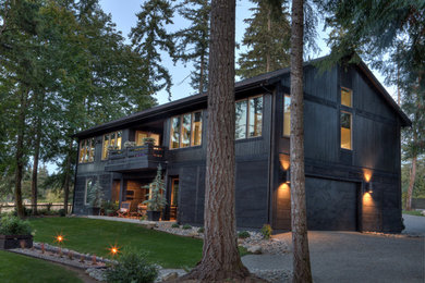 Diseño de fachada de casa negra moderna de tamaño medio de dos plantas con revestimiento de madera, tejado a dos aguas y tejado de teja de madera