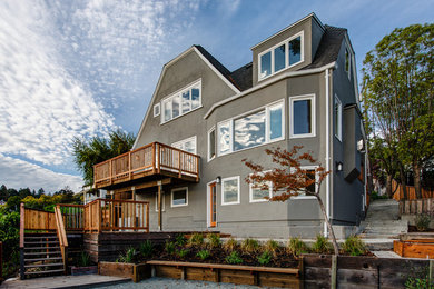 Elegant gray three-story stucco exterior home photo in San Francisco with a clipped gable roof