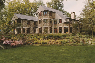 Imagen de fachada de casa moderna extra grande de tres plantas con revestimiento de piedra y tejado de teja de madera