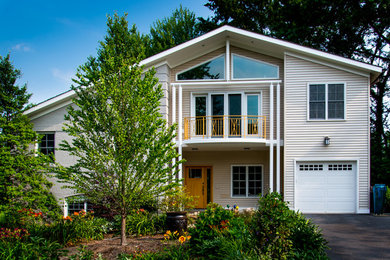 Esempio della facciata di una casa beige contemporanea a due piani di medie dimensioni con rivestimento in mattoni e tetto a padiglione