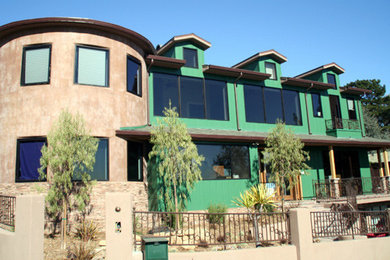 Modelo de fachada multicolor tradicional renovada de tamaño medio de dos plantas con revestimientos combinados y tejado a cuatro aguas
