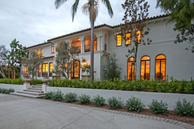 Example of a large tuscan white two-story exterior home design in Los Angeles with a shingle roof