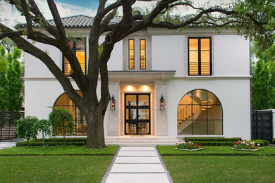 Cette image montre une grande façade de maison blanche design en stuc à un étage avec un toit à quatre pans et un toit en tuile.