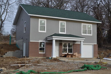 Kleines, Zweistöckiges Klassisches Einfamilienhaus mit Vinylfassade, grauer Fassadenfarbe, Satteldach und Schindeldach in St. Louis