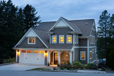 Ejemplo de fachada de casa gris de estilo americano grande de tres plantas con revestimientos combinados y tejado de teja de madera