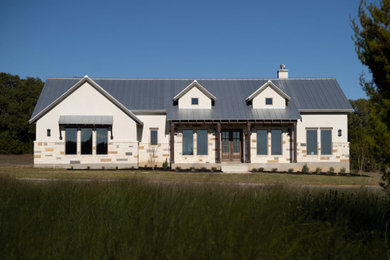 Inspiration for a large farmhouse beige one-story house exterior remodel in Other with a metal roof