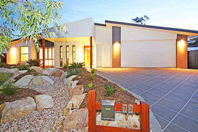 Ejemplo de fachada de casa multicolor minimalista de tamaño medio a niveles con revestimientos combinados, tejado plano y tejado de metal