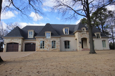 Large elegant beige two-story stone exterior home photo in Little Rock with a hip roof