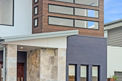 Imagen de fachada de casa contemporánea grande de dos plantas con revestimientos combinados y tejado de metal