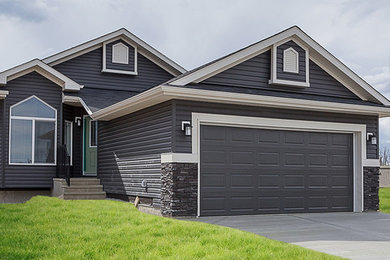 Cette photo montre une façade de maison grise de plain-pied avec un revêtement en vinyle et un toit en shingle.