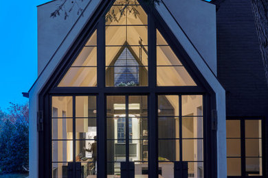 Imagen de fachada de casa negra moderna de tamaño medio de dos plantas con revestimiento de metal y tejado de metal