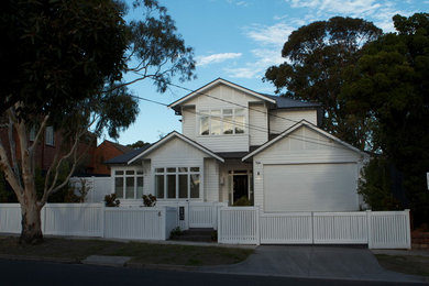 Photo of a large and white classic two floor house exterior in Melbourne with wood cladding.