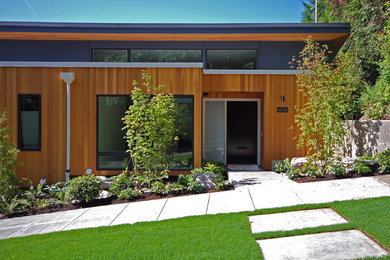 Foto della facciata di una casa piccola marrone moderna a due piani con rivestimento in legno