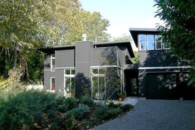 Diseño de fachada negra actual de tamaño medio de dos plantas con revestimiento de madera y tejado de un solo tendido