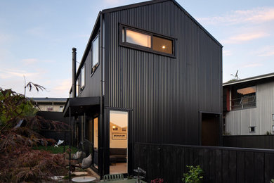 Diseño de fachada negra contemporánea de dos plantas con revestimiento de metal